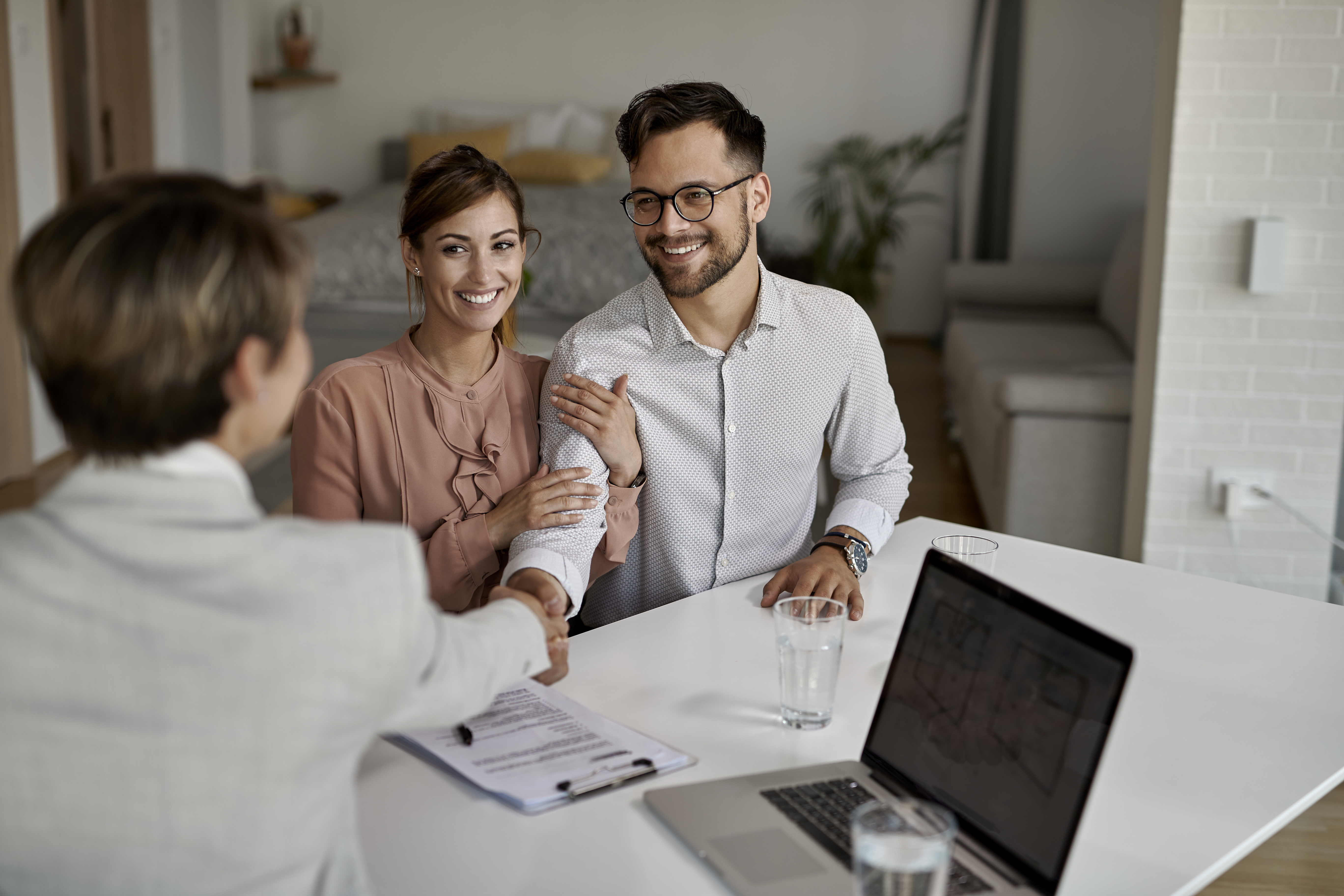 Happy couple meeting with their real estate agent in the office.